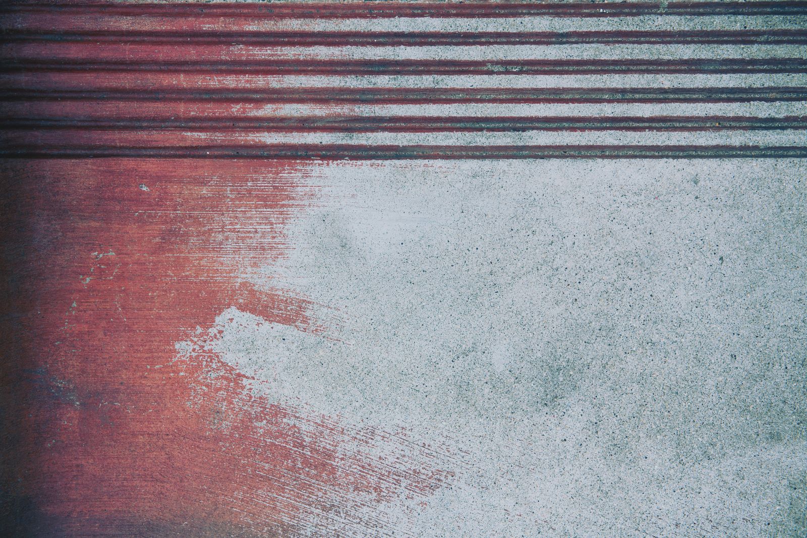 Coloured concrete surface with red and grey brushed texture