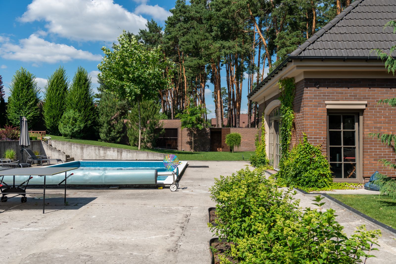 Modern outdoor concrete patio beside a residential pool area