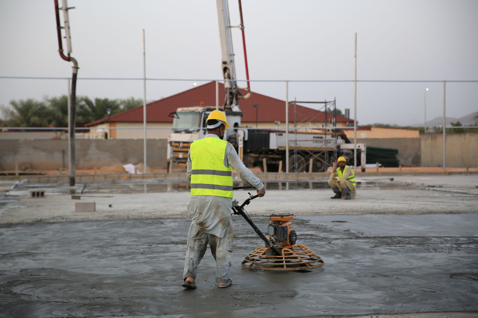 Contractor smoothing and resurfacing a concrete driveway surface