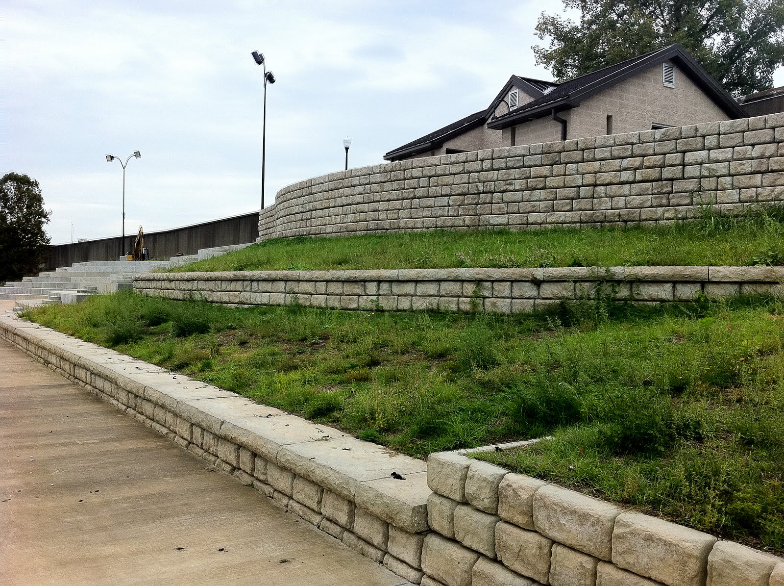 Large precast concrete retaining wall blocks supporting an outdoor paved area